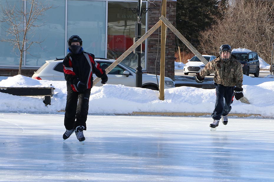 2 skaters on an outdoor rink